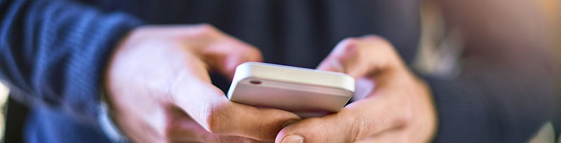 hombre escribiendo en teléfono